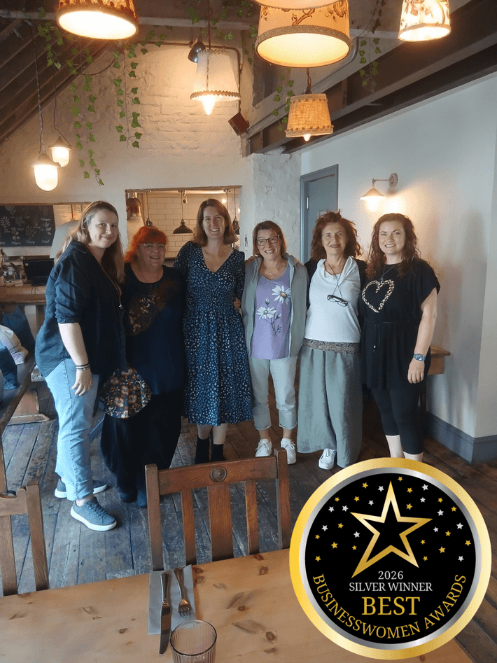 6 women posing for the camera in a line in a pub setting.  The Best Businesswoman awards 2026 logo is on the image