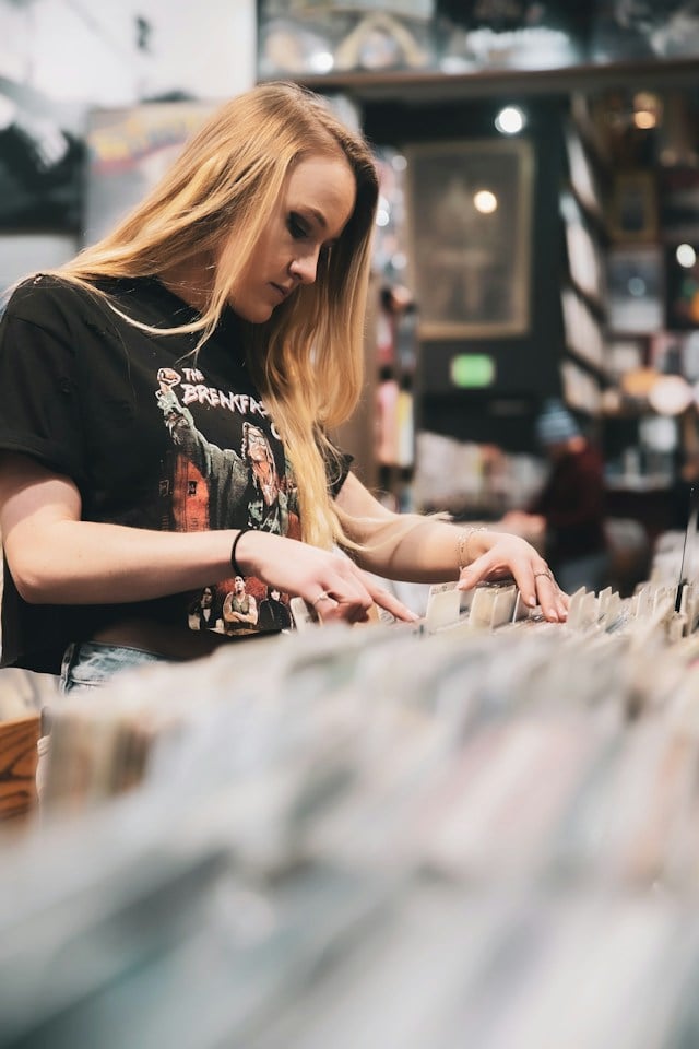 A woman counting Vinyl in a music shop.
