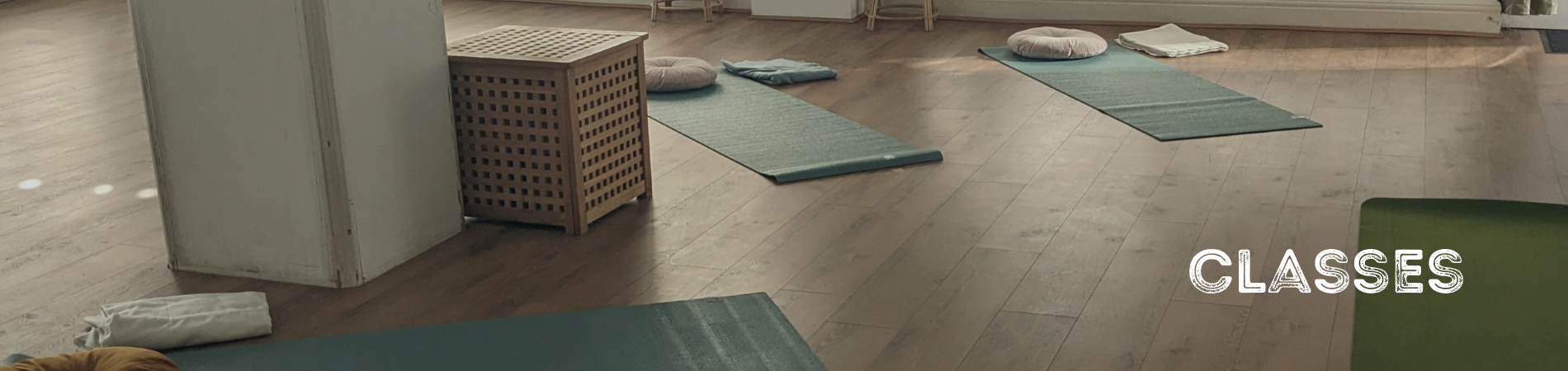 Yoga mats laid out in a semi circle in a yoga studio.