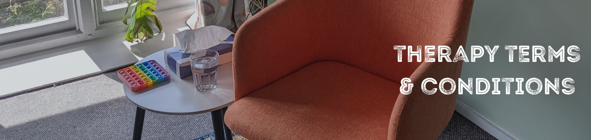 An empty orange chair in a therapy room setting.
