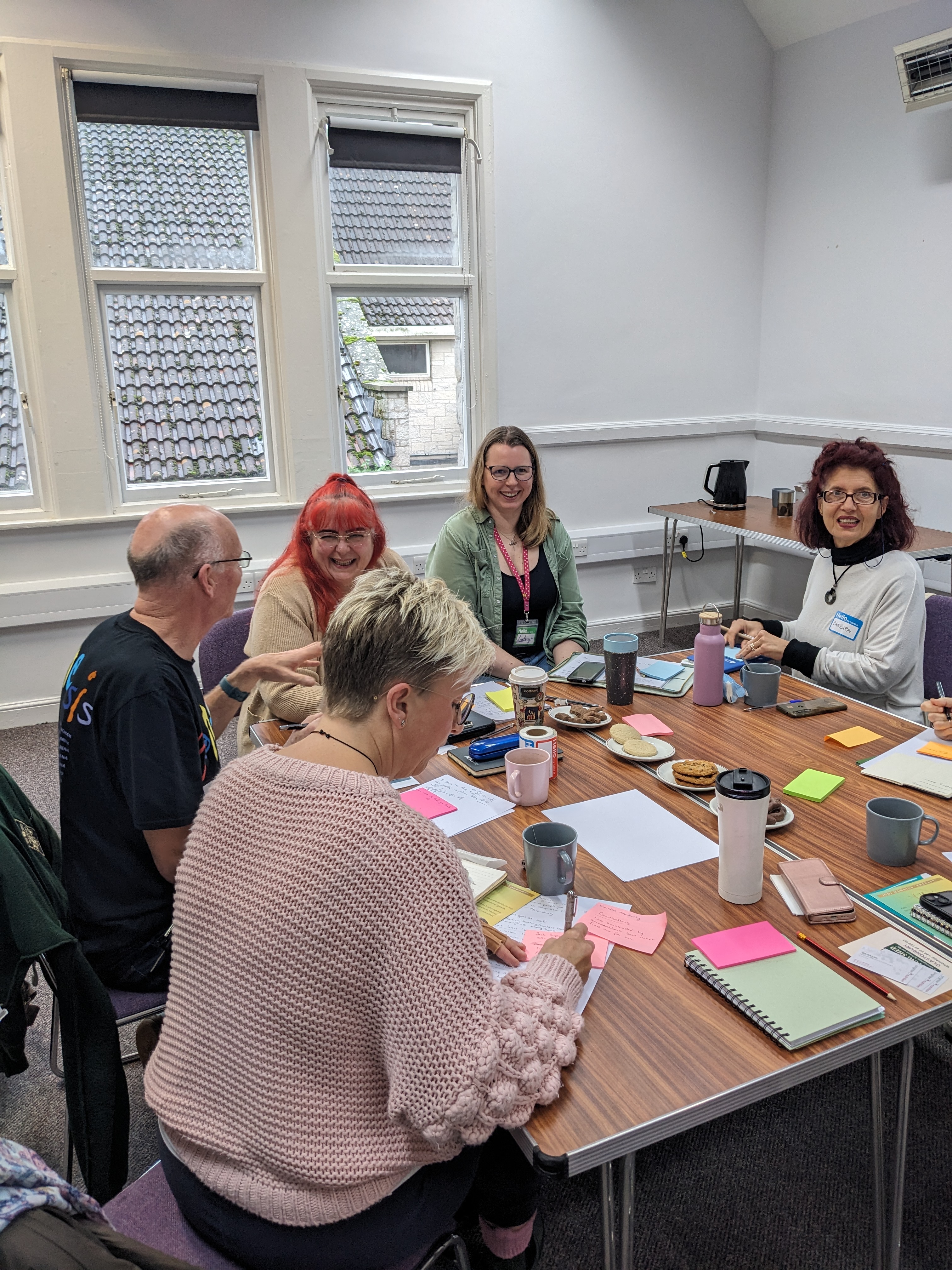 Various therapists sitting around a table during a workshop at a meetup.