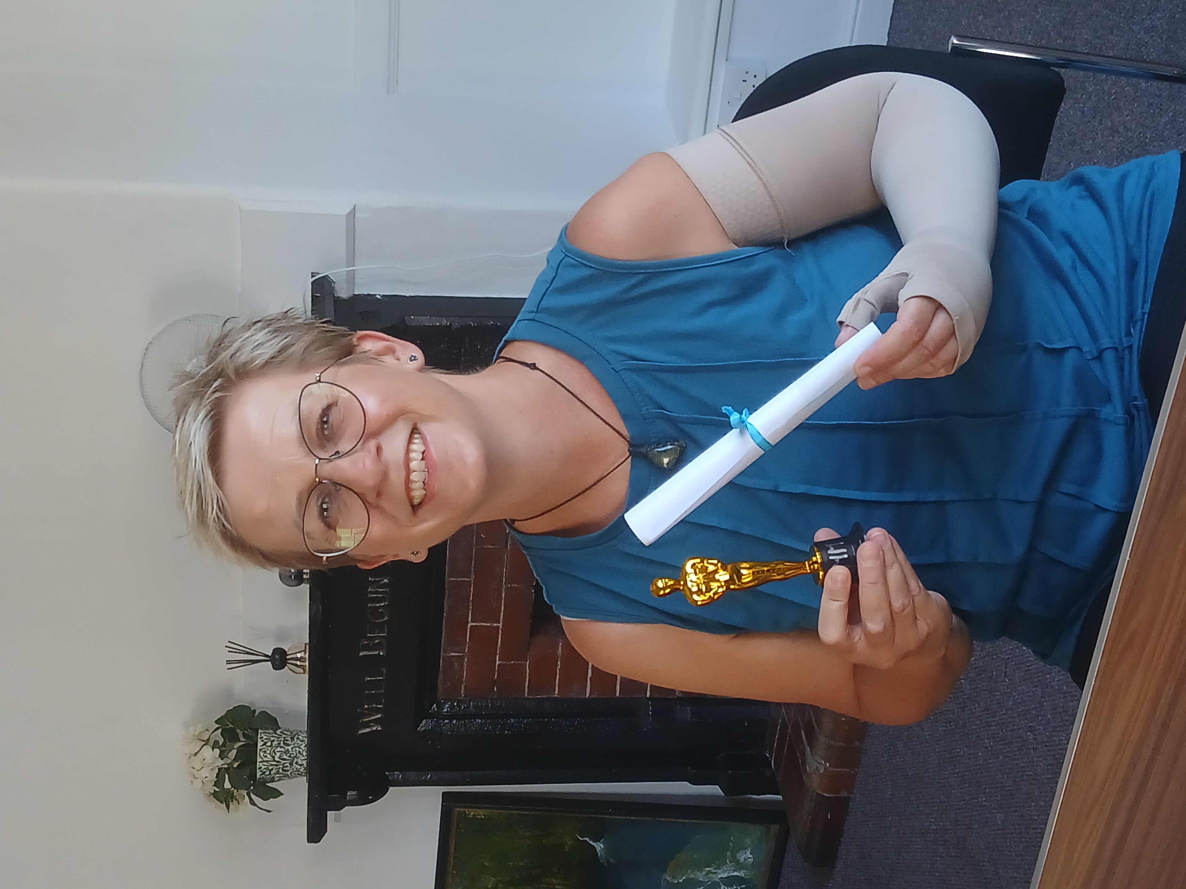 Winner of the Community Spirit recognition holding a her trophy guy and a rolled up certification.