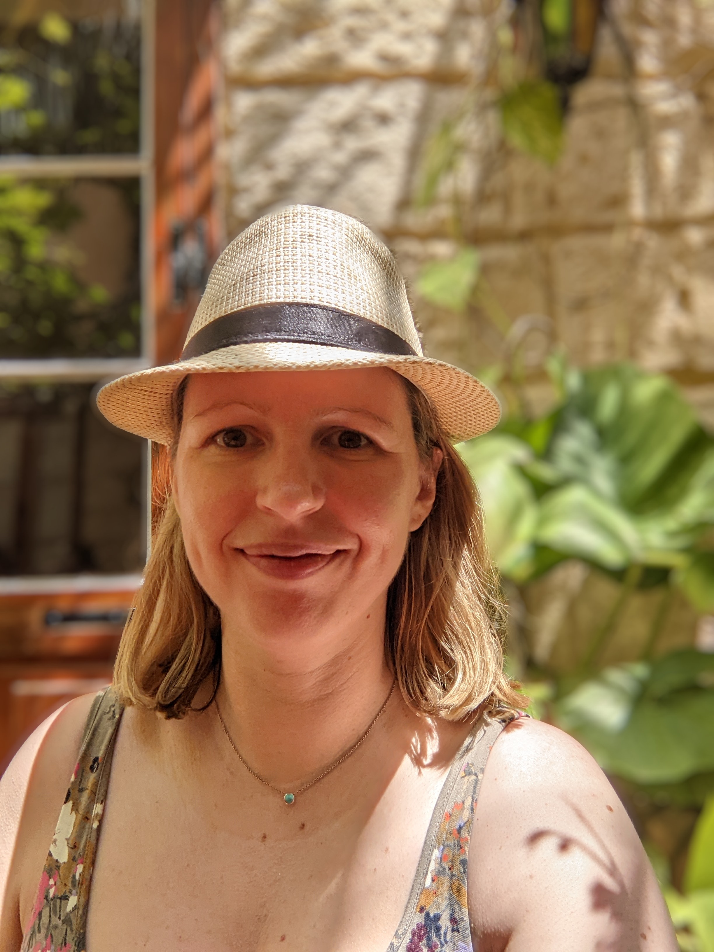 Lindsay wearing a sun hat facing the camera.