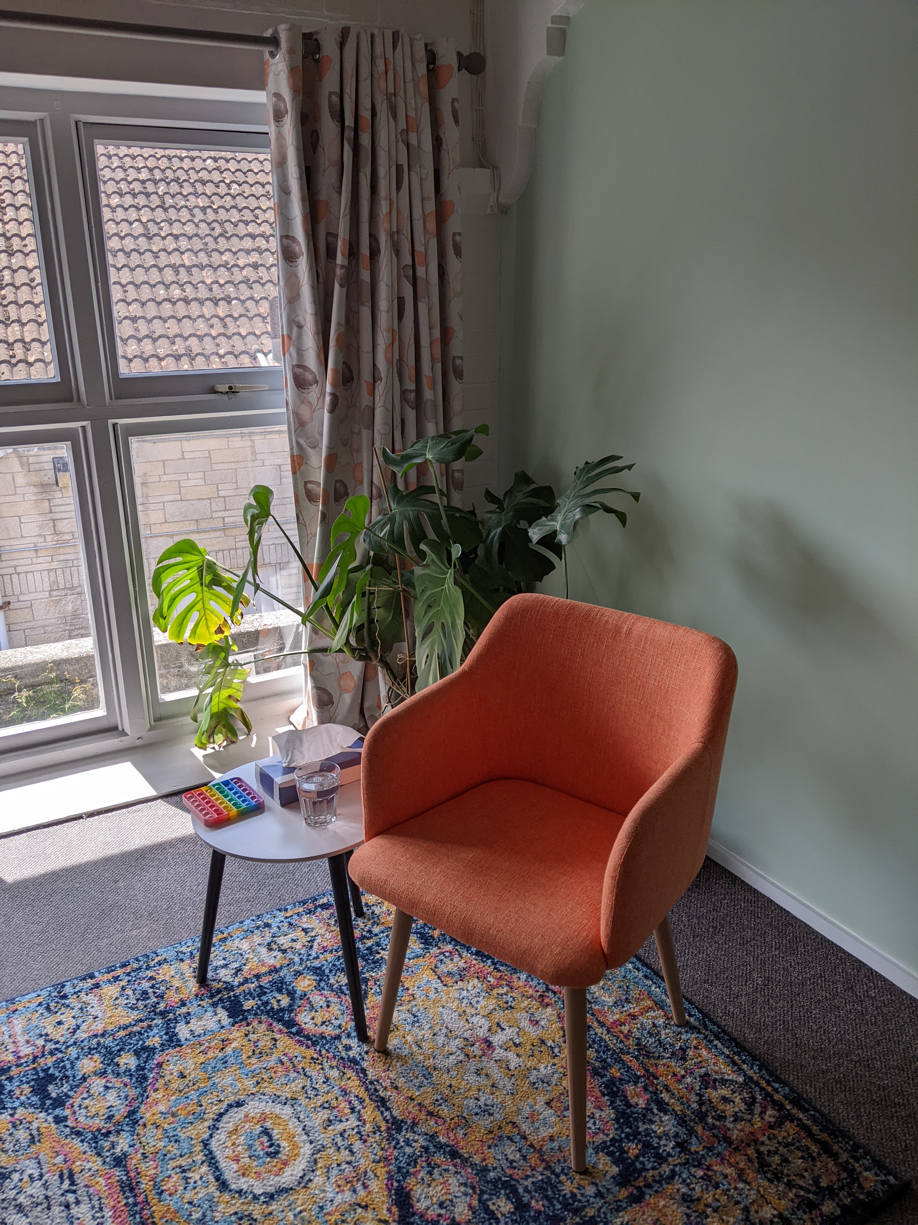 An empty orange chair in a therapy room setting.